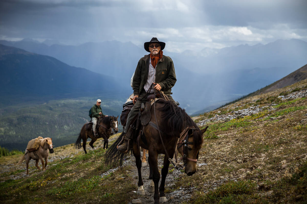 A horseback guide leads a group through vast countryside.