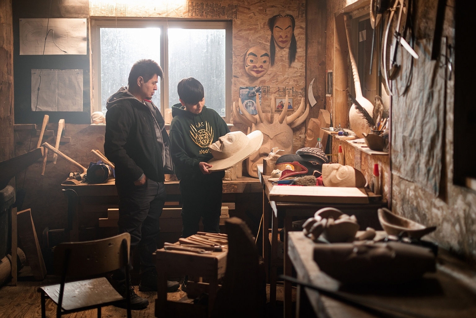 Nisga'a carver Calvin McNeil looks at First Nations artwork in a carving shed with his son, Jacob.