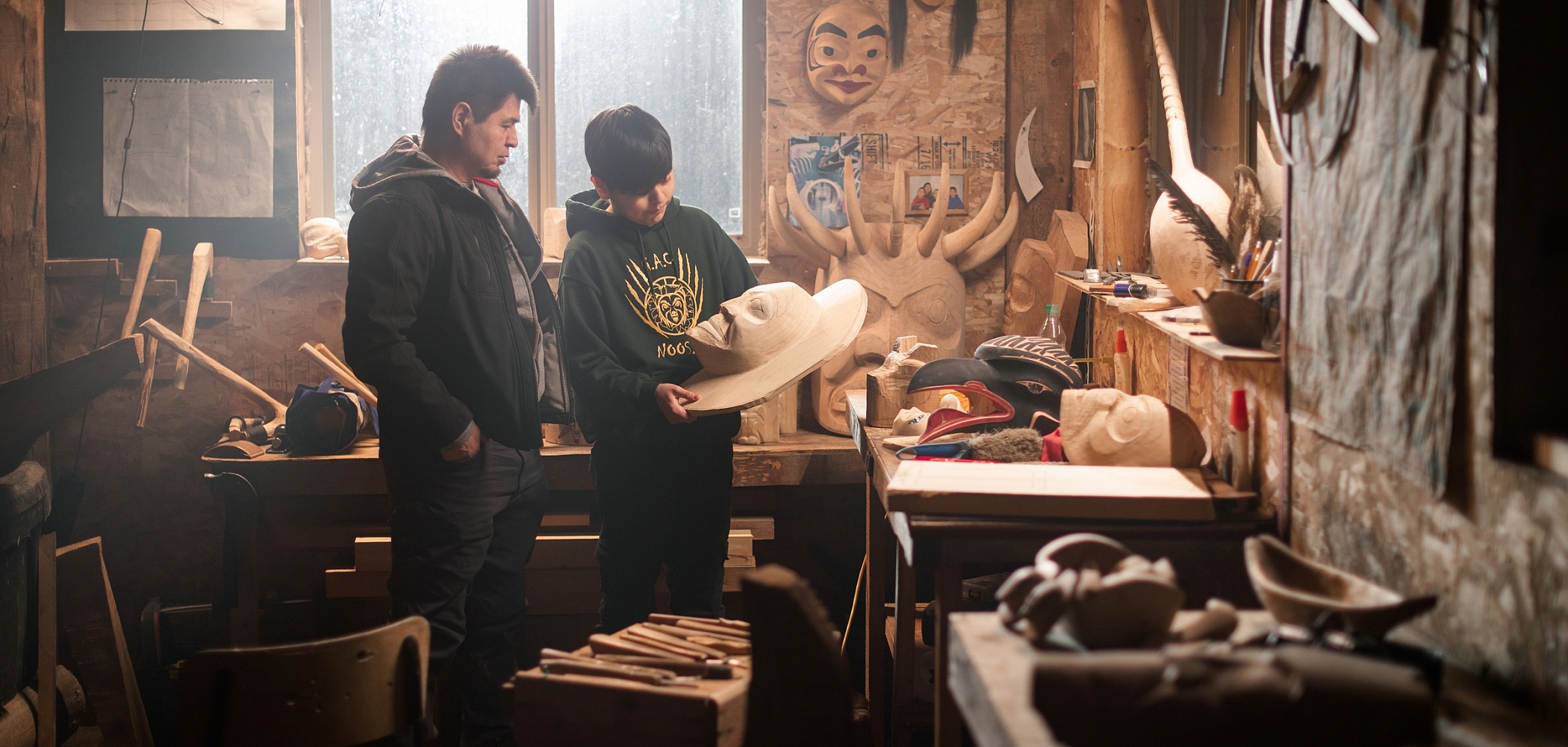 Nisga'a carver Calvin McNeil looks at First Nations artwork in a carving shed with his son, Jacob.