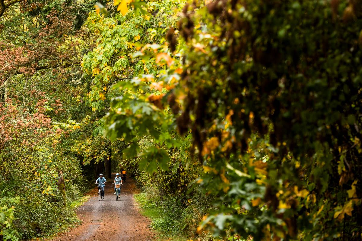 A couple cycling the Galloping Goose Trail in Victoria